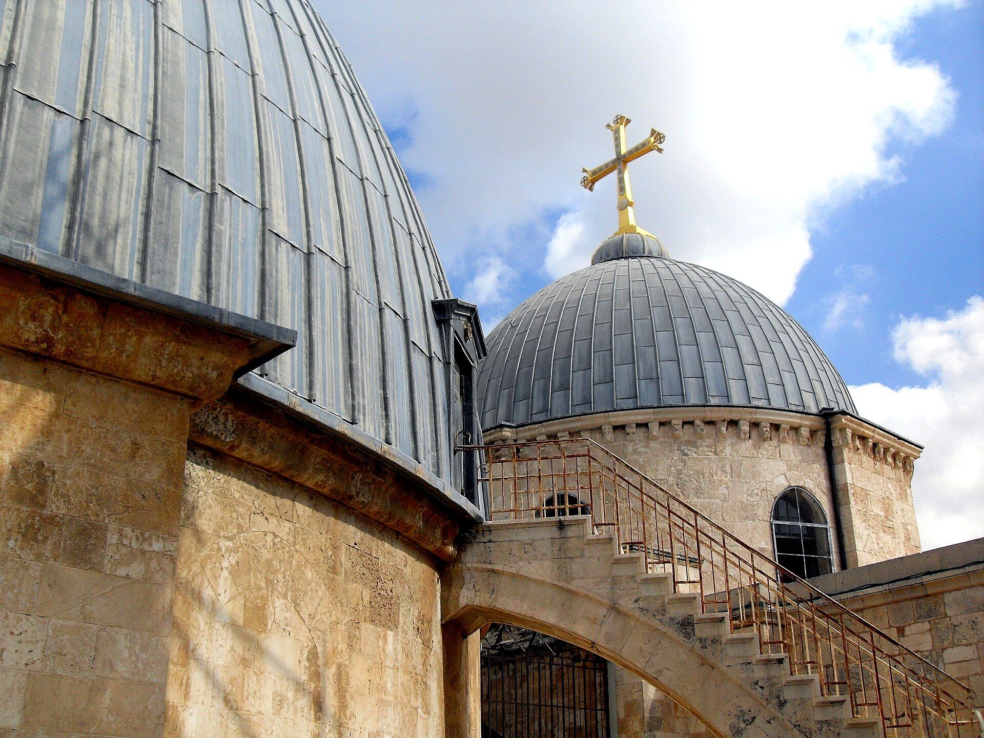 Stone stairs and the weathered domes of the Holy Sepulchre in Jerusalem