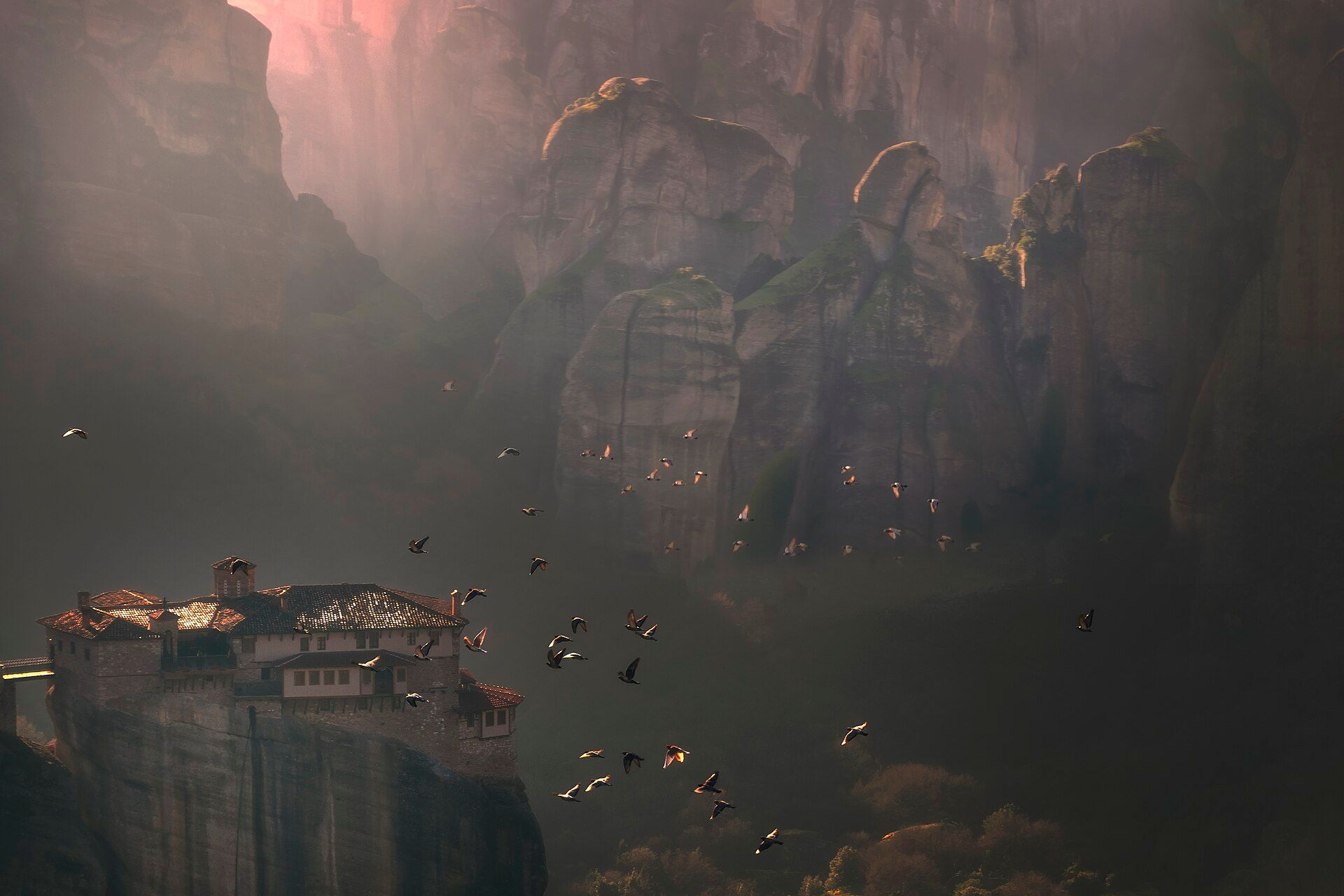 A monastery on a rock pillar at Meteora in misty light
